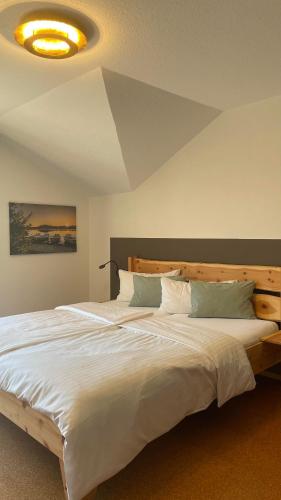 a bedroom with a large white bed with a ceiling at Traumplatz im Allgäu in Rettenberg