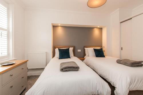 two beds sitting next to each other in a bedroom at Stunning Seafront Apt-just Steps To Viking Bay in Kent