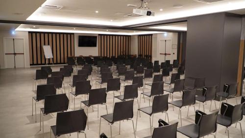 a conference room with black chairs and a projection screen at Best Western Hotel Massafra in Massafra