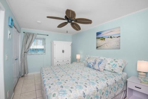 Un dormitorio con una cama y un ventilador de techo. en Crescent Shore 201 by Sun Palace Vacations, en Fort Myers Beach