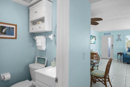 Un baño azul con inodoro y lavabo. en Crescent Shore 201 by Sun Palace Vacations, en Fort Myers Beach