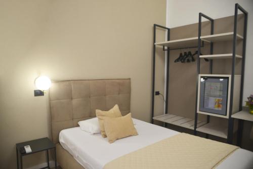a bedroom with a bed and a book shelf at Hotel Torino in Brindisi