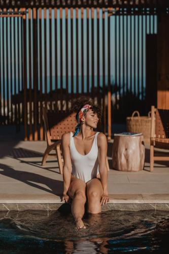 a woman sitting in a pool of water at Happy Cretan Suites in Agia Pelagia