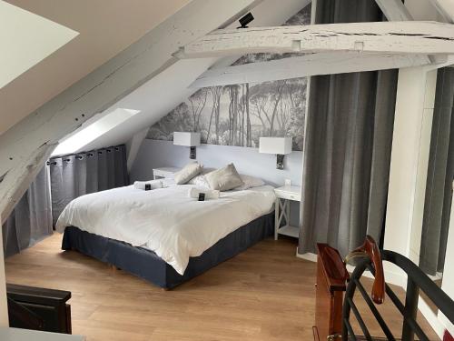 une chambre avec un grand lit dans un grenier dans l'établissement Appartement Versailles château, à Versailles