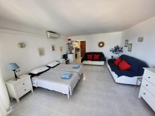 una sala de estar con una cama y un sofá en Beach Front La Cala Penthouse studio Apartment, en La Cala de Mijas