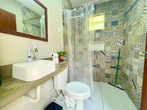 ein Badezimmer mit Toilette, Waschbecken und Dusche in der Unterkunft Flat Peace - 10min Ponta Negra in Natal