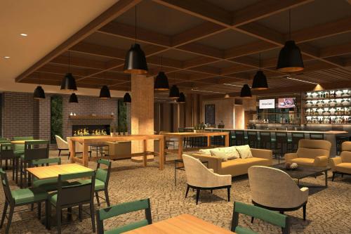 a restaurant with tables and chairs and a bar at Courtyard by Marriott Milwaukee Brookfield at Poplar Creek in Brookfield