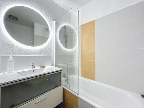 une salle de bain blanche avec un lavabo et un miroir dans l'établissement 3652-Appartement 4 couchages avec piscine, à Argelès-sur-Mer