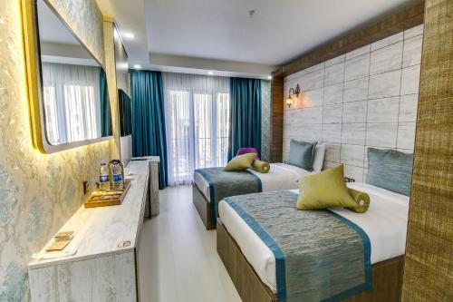 a hotel room with two beds and a mirror at Elite World Nest Sivas in Sivas