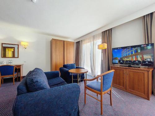 a living room with a couch and a tv at Vivaldi Hotel in St Julian's