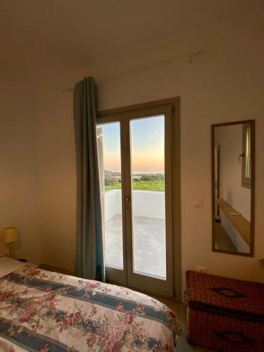 a bedroom with a bed and a large window at Lizzy's Escape 1st floor in Kampos Paros