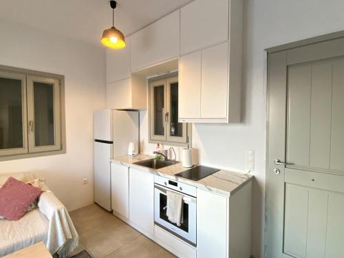 a white kitchen with a sink and a refrigerator at Lizzy's Escape 1st floor in Kampos Paros