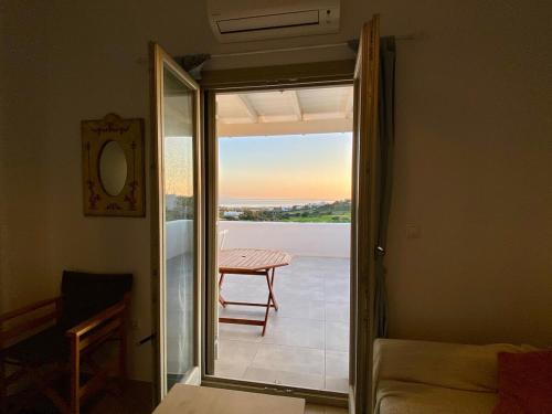 a room with a door open to a balcony with a table at Lizzy's Escape 1st floor in Kampos Paros