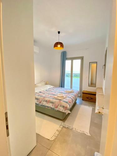 a bedroom with a bed and a large window at Lizzy's Escape 1st floor in Kampos Paros