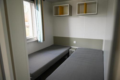 une chambre avec deux lits et une fenêtre dans l'établissement Ferienpark Süderstapel - Eiderlodge 1, à Süderstapel