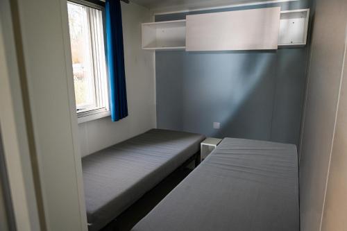 una piccola stanza con un letto e una finestra di Ferienpark Süderstapel - Eiderlodge 3 a Süderstapel