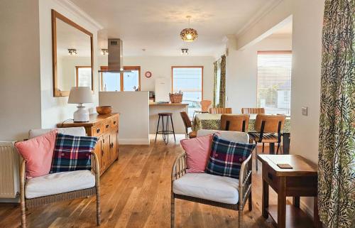 a living room with two chairs and a kitchen at Lochside in Dornie