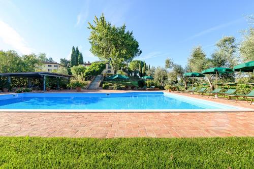 a large swimming pool with chairs and umbrellas at Villa Delia Hotel and Cooking School in Ripoli