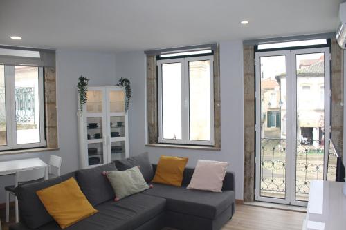 a living room with a couch and some windows at Casinhas Dom Afonso by Hotel Dom Afonso in Monção