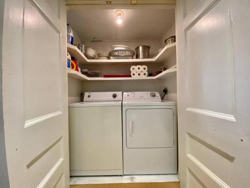 a small kitchen with a washer and dryer at Unique Stay! Converted Church In Idyllic Location in St. John's