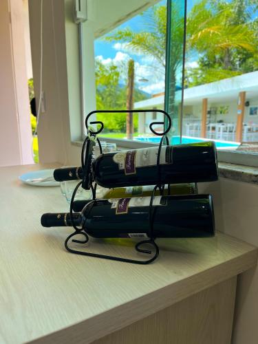 a group of four wine bottles stacked on a shelf at Pousada Lírios do Campo Hidromassagem - Sauna-Ar condicionado - Piscina - salão de jogos - 200 metros da praia Jabaquara in Paraty