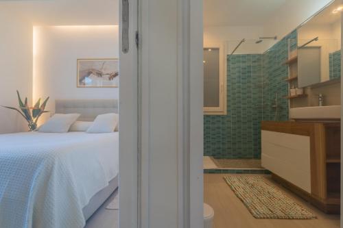a bedroom with a bed and a bathroom with a shower at Tramonto A Nordovest in Favignana