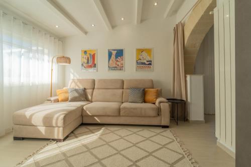 a living room with a couch and a staircase at Tramonto A Nordovest in Favignana