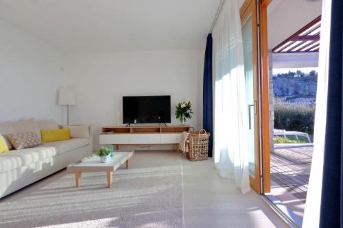 a living room with a couch and a tv at Portopiccolo Apartments in Sistiana