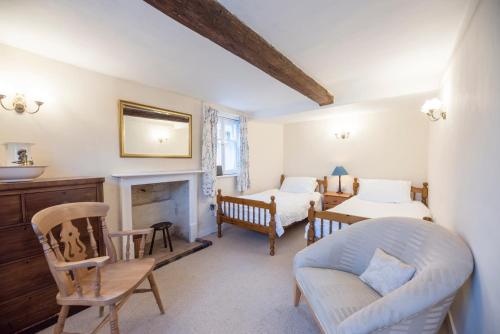 a bedroom with two beds and a couch and a fireplace at Varley House, Saxmundham in Saxmundham
