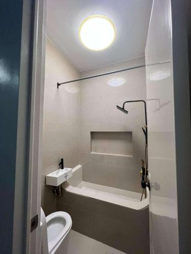 a bathroom with a white toilet and a sink at Couple - Private Jacuzzi Pool in Mabalacat