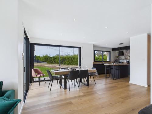 une cuisine et une salle à manger avec une table et des chaises dans l'établissement Maison moderne pour 8 à 400m de la plage, à Plouguerneau