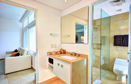 a bathroom with a sink and a toilet and a shower at Luxurious & Central Condo In Playa Steps From The Beach in Playa del Carmen