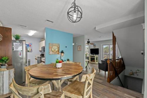 a dining room and living room with a wooden table and chairs at Bikini Bottom Destin Harbor Private Gated Beach in Destin