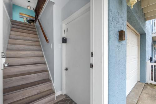 a hallway with a white door and stairs at Bikini Bottom Destin Harbor Private Gated Beach in Destin