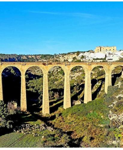 a bridge over a river with a city in the background at B&b La Campanella in Palagianello