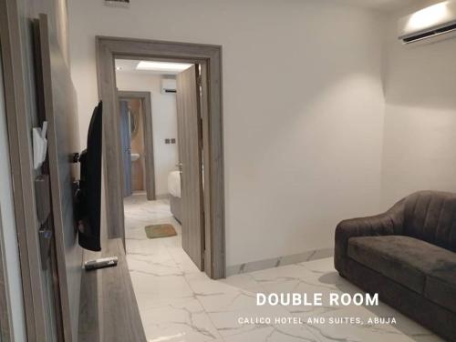 a living room with a door and a couch at Calico Hotel and Suites, Abuja in Gwarinpa