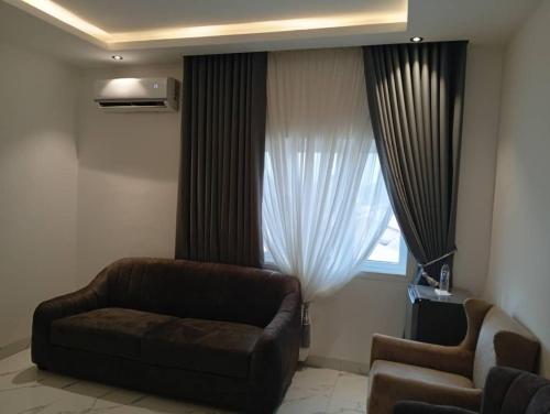 a living room with a couch and a window at Calico Hotel and Suites, Abuja in Gwarinpa