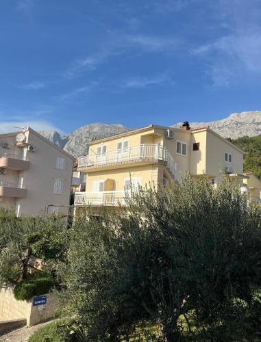 a building on a hill with mountains in the background at Hugo in Promajna