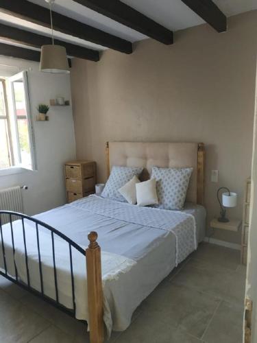 une chambre avec un grand lit dans une pièce dans l'établissement la Maison du Bonheur, à Vidauban