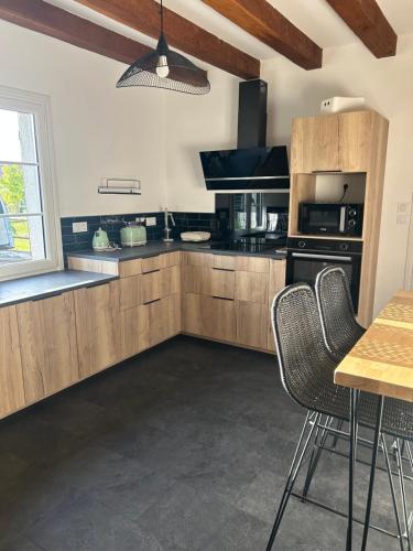 une cuisine avec des armoires en bois et une table et des chaises dans l'établissement Gite de Charme Tour en Sologne avec Jacuzzi, à Tour-en-Sologne