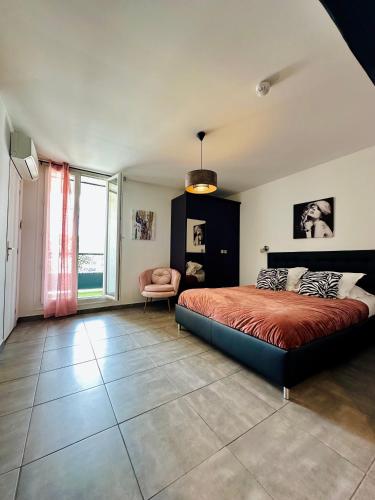 a bedroom with a bed and a chair in it at Hôtel Eden Cassis - centre-ville- piscine chauffée, jacuzzi et sauna - parking privé in Cassis