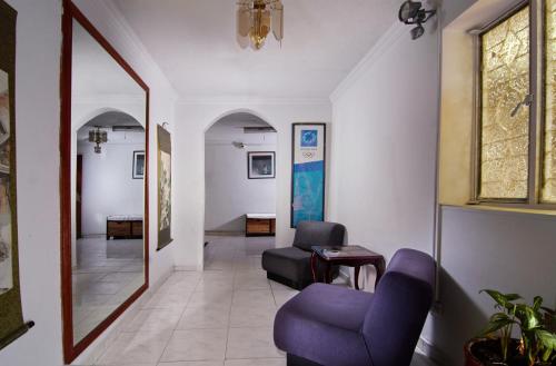 a hallway with a blue chair and a mirror at Deportel Bogotá in Bogotá