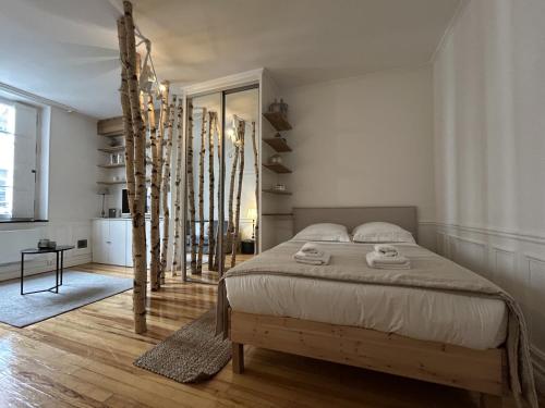 une chambre avec un lit avec deux serviettes dessus dans l'établissement La Suite Carmen - Hypercentre de Reims, à Reims