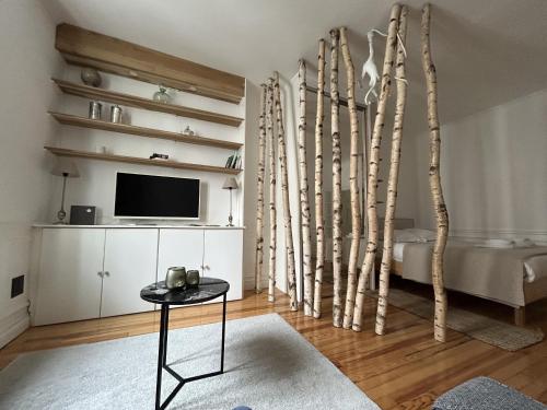 Cette chambre comprend un lit, une télévision et des arbres. dans l'établissement La Suite Carmen - Hypercentre de Reims, à Reims