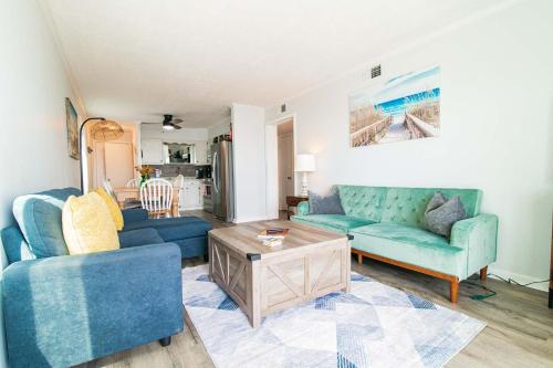 a living room with two blue couches and a table at Windy Waves Top Location w Pool in Myrtle Beach