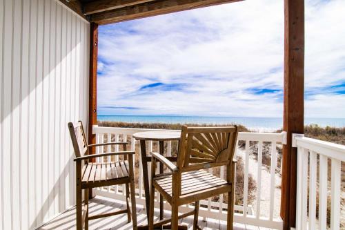 a porch with two chairs and a table and a view of the ocean at Windy Waves Top Location w Pool in Myrtle Beach