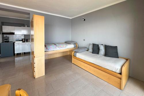a bedroom with two beds and a kitchen at Appartamento Alberti con vista lago in Madonna del Sasso