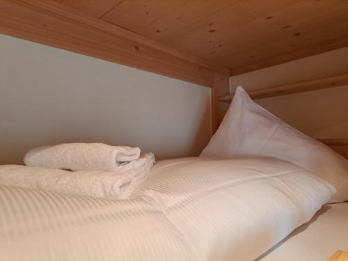 a bed with two white towels on top of it at Laax Chalet by Quokka 360 - Charming Chalet with private patio in Laax