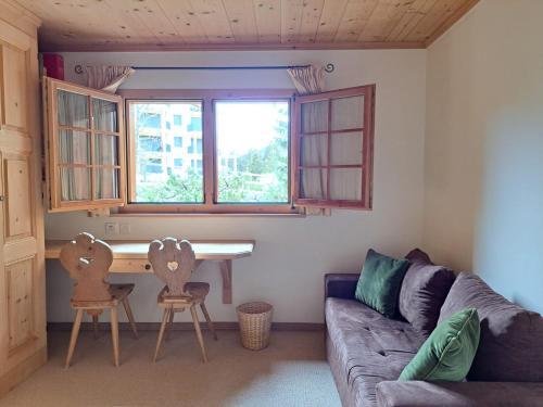 Una sala de estar con un sofá, una mesa y sillas. en Laax Chalet by Quokka 360 - Charming Chalet with private patio, en Laax