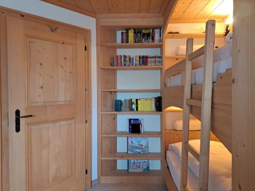 a room with a bunk bed and a door at Laax Chalet by Quokka 360 - Charming Chalet with private patio in Laax
